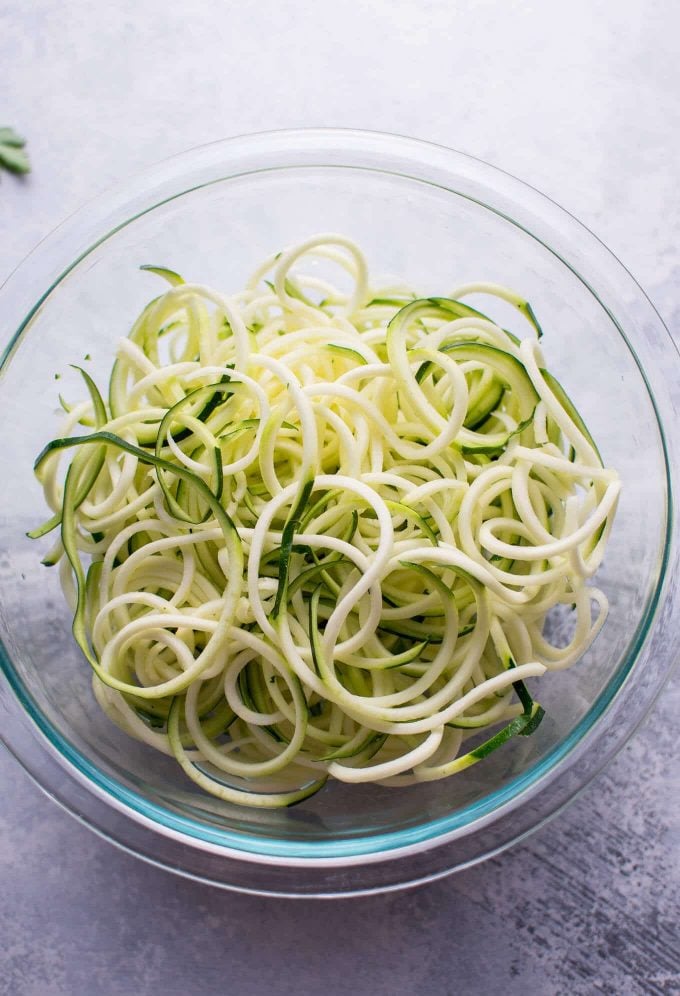 glass bowl with raw zucchini noodles