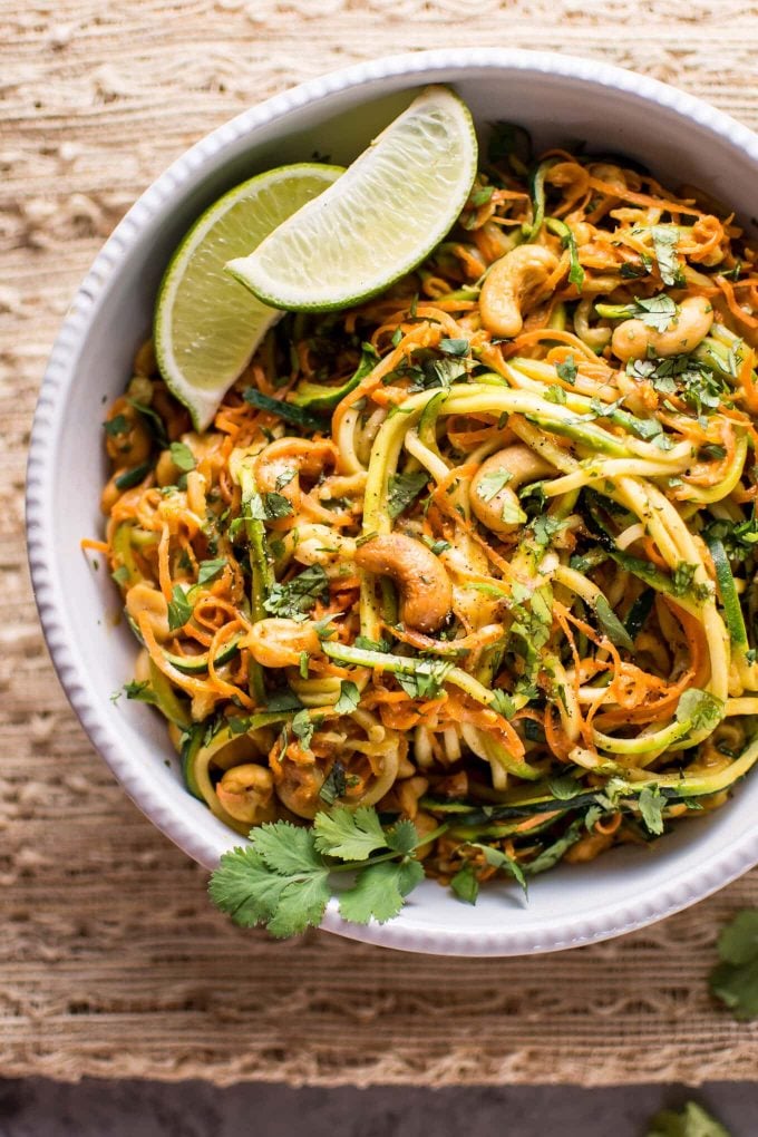 close-up of 15-minute garlic lime cashew zoodles in a bowl with lime wedges