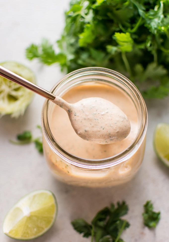 close-up of chipotle cilantro lime ranch dressing in a mason jar with a spoon