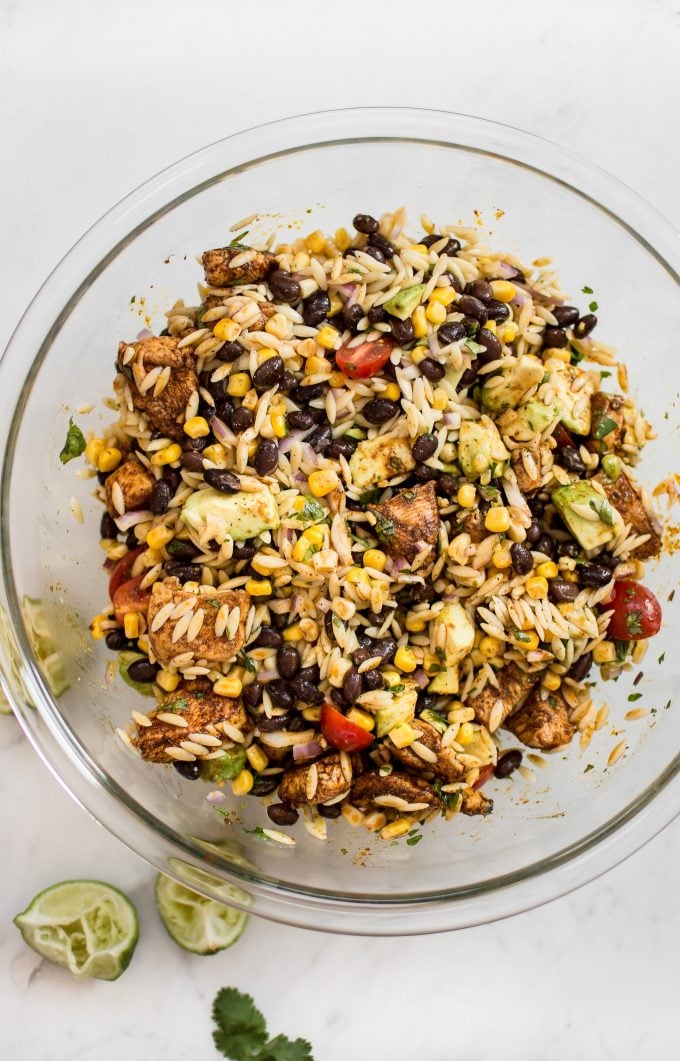 Mexican chicken salad with orzo and avocado in a glass bowl