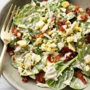 a bowl with spinach salad with a fork