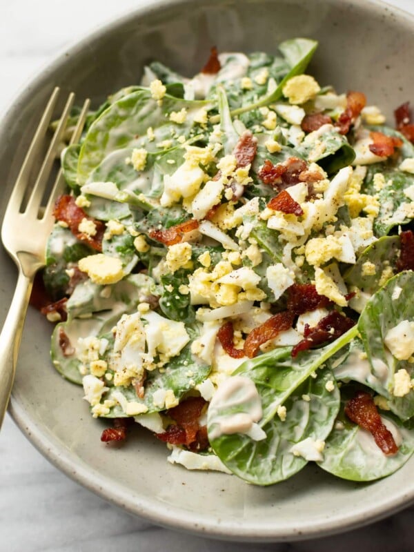 a bowl with spinach salad with a fork