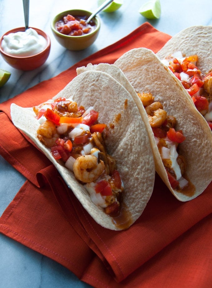 sweet and smoky BBQ shrimp tacos on a red cloth napkin