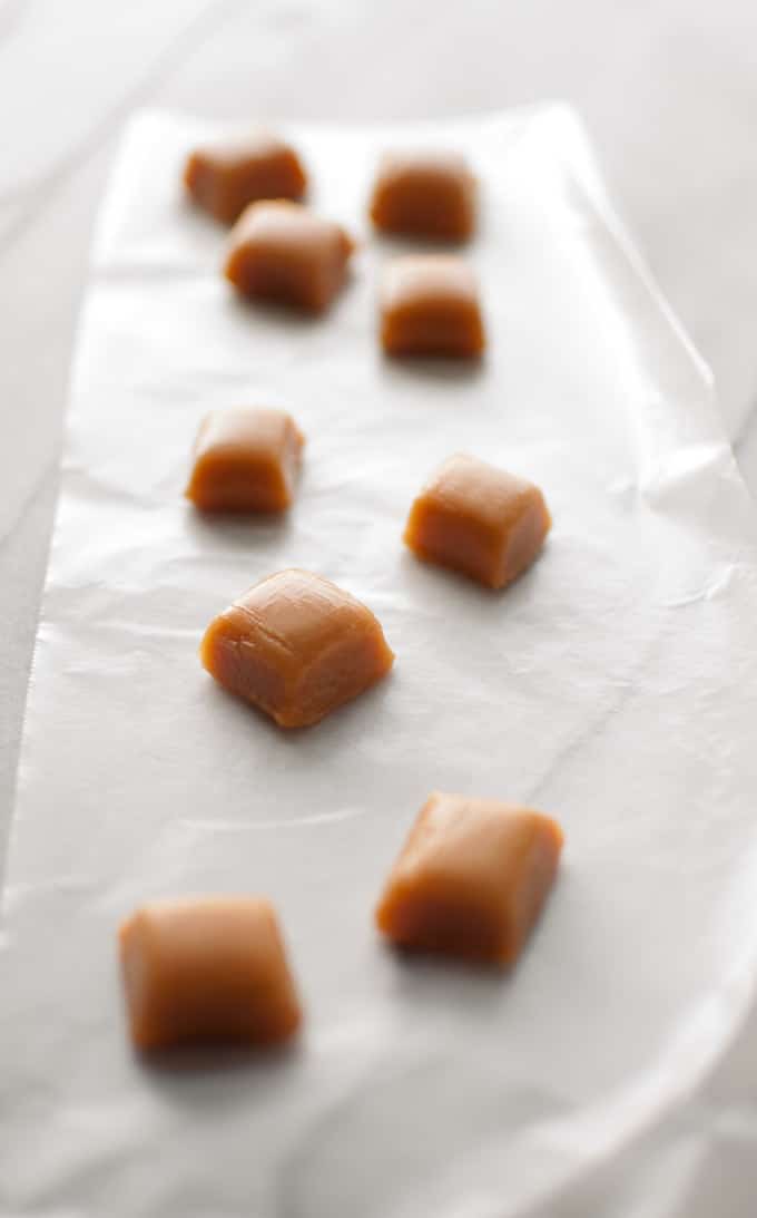 individual pieces of homemade caramels on wax paper