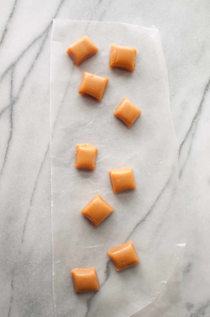 several homemade caramels on a marble surface