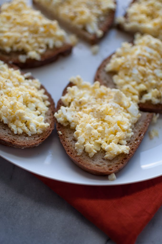 several slices of rye bread with egg spread on a plate