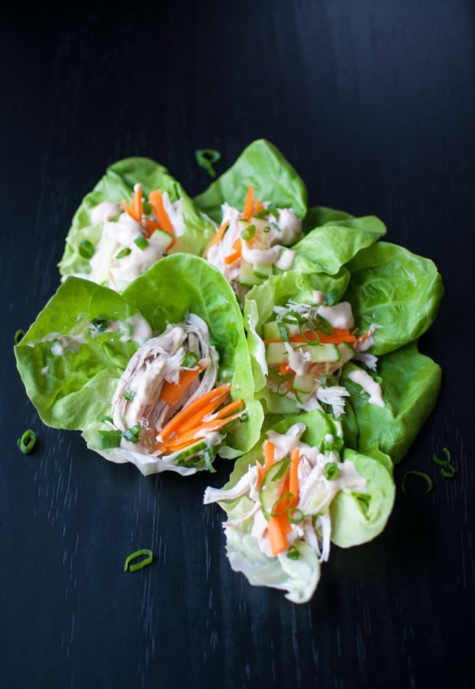 several low-carb Asian chicken lettuce wraps on a black surface