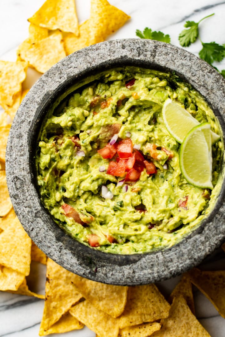 easy guacamole in a molcajete surrounded by tortilla chips