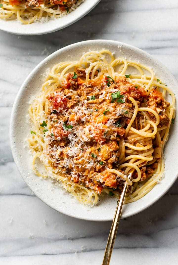 the best spaghetti sauce on top of spaghetti in a shallow bowl being twirled with a fork