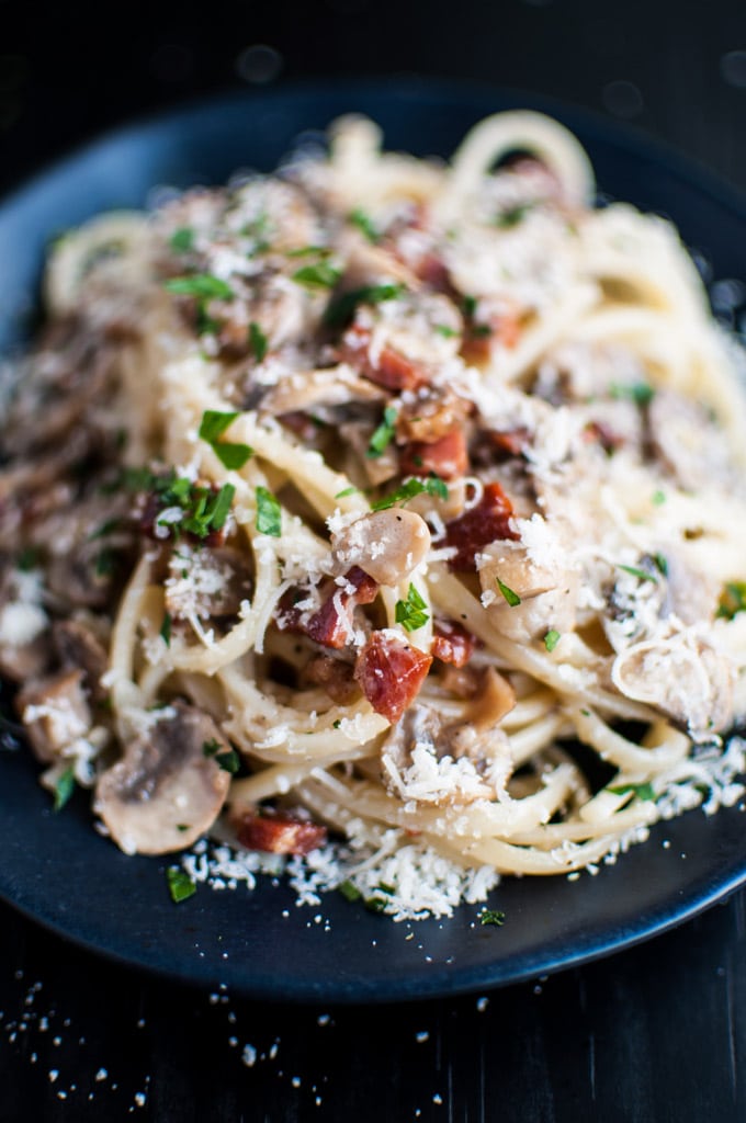close-up of pasta with pancetta, mushrooms, garlic, and grated parmesan