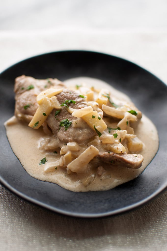 black plate with pork tenderloin medallions in brandy and apple cream sauce