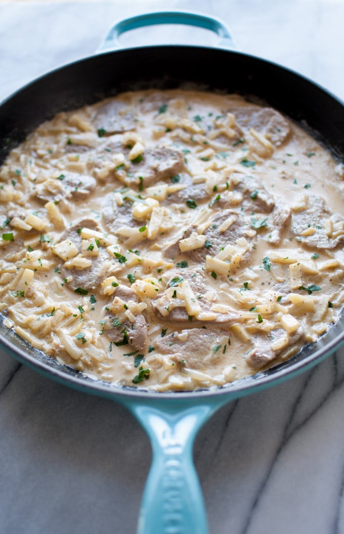 skillet with pork tenderloin medallions in brandy and apple cream sauce