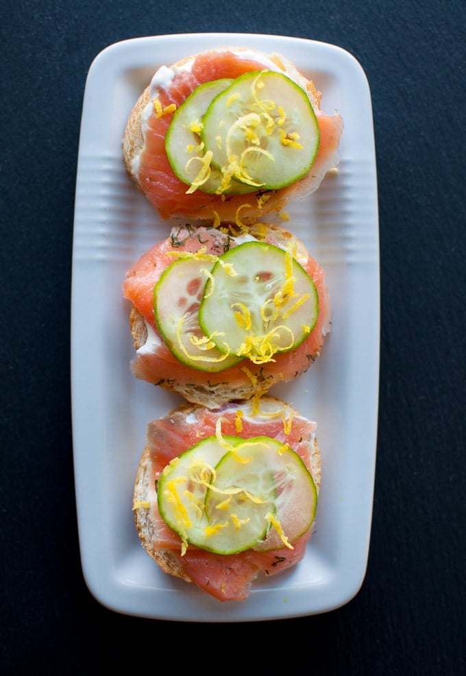 rectangular white bowl with three smoked salmon canapes with easy lemon truffle mayo and cucumber