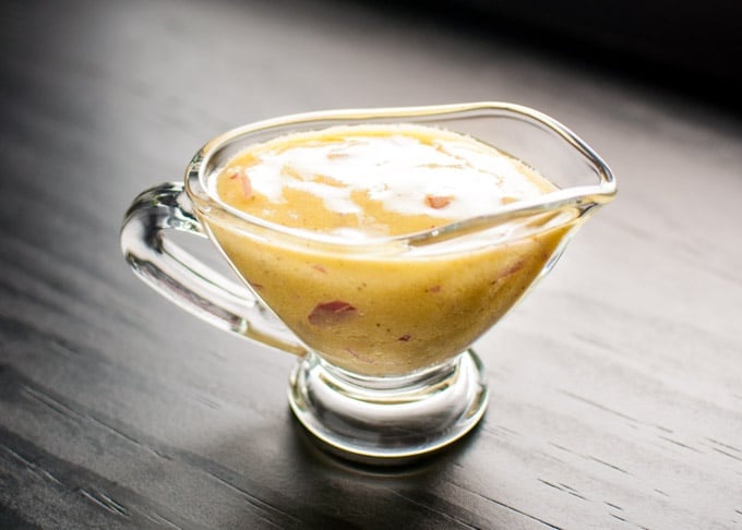 a small glass serving bowl of garlic, rice vinegar, Dijon mustard, and olive oil vinaigrette