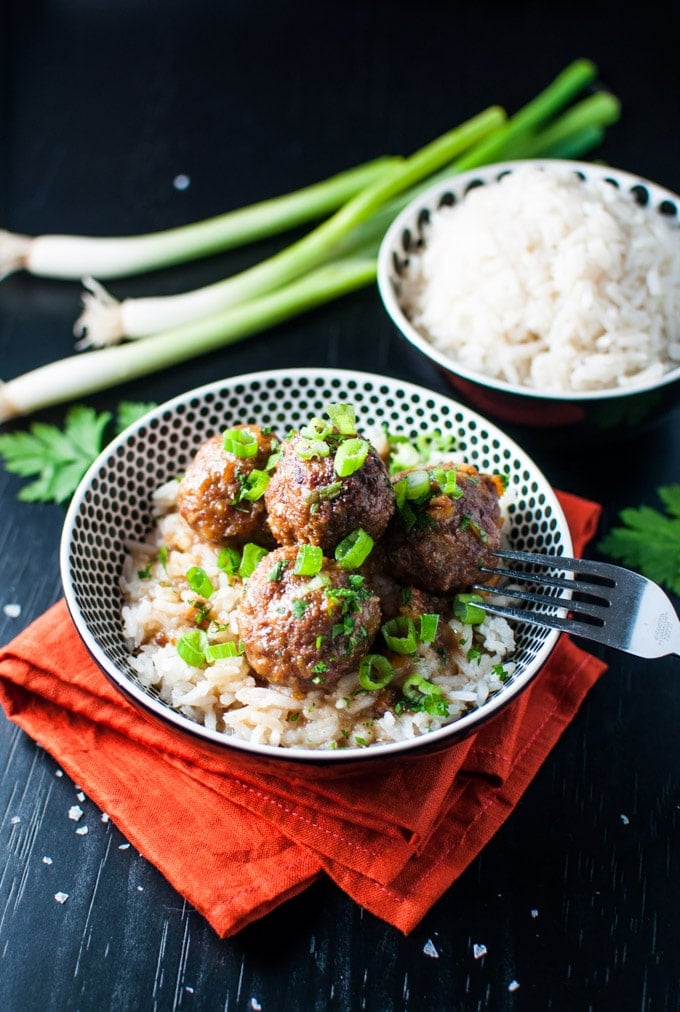 bowl with slow cooker cranberry and orange meatballs and bowl of rice