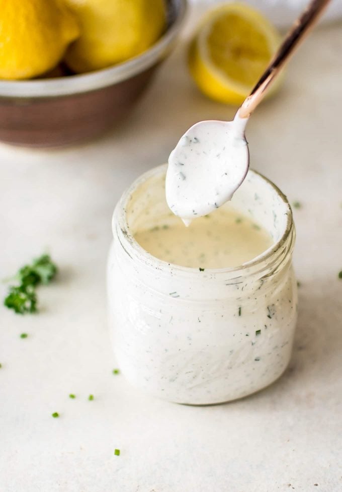 glass jar with homemade ranch dressing and a spoon with dressing on it
