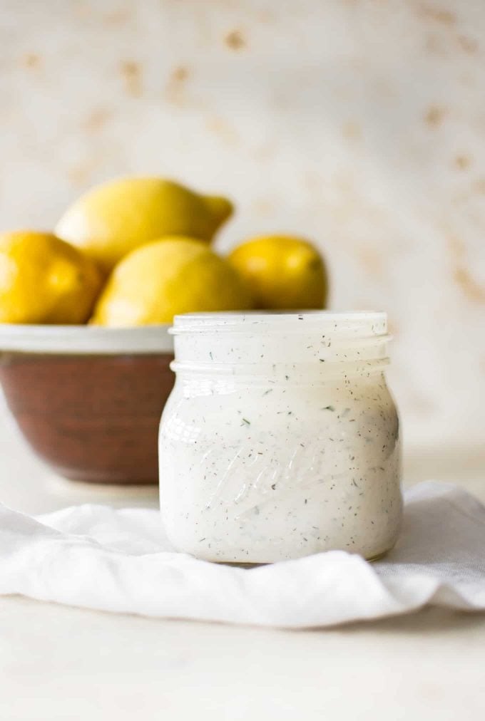 mason jar of easy homemade ranch dressing with a bowl of lemons in the background