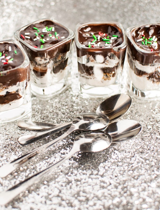 several containers of layered Oreo and Reese desserts with spoons
