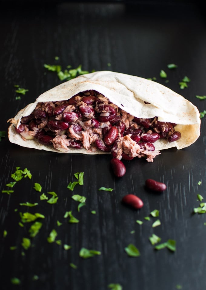 half a pita bread stuffed with tuna and bean salad with parsley