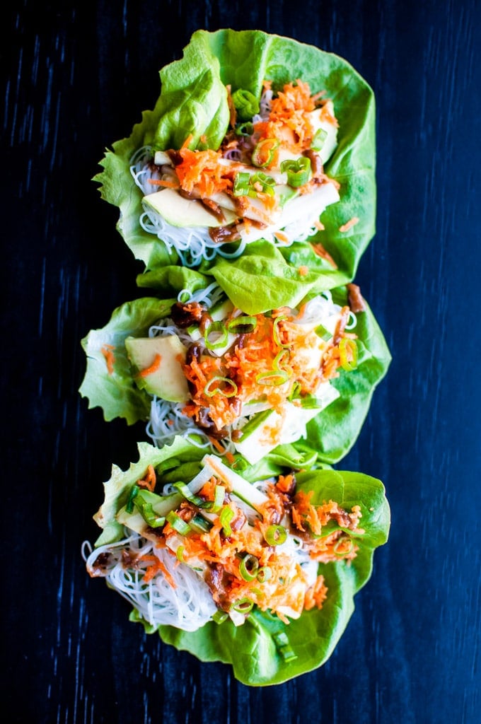 close-up of several vegetable lettuce wraps with a sweet peanut sauce