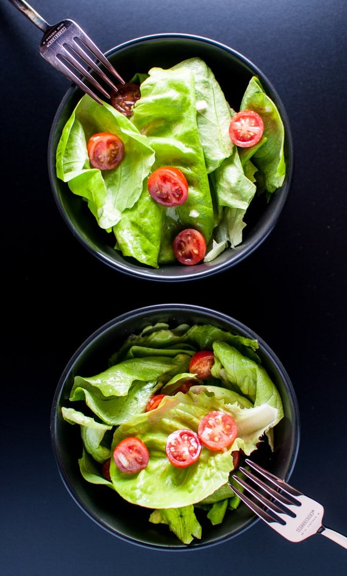 two bowls of salad with butter leaf lettuce, tomatoes, and the best vinaigrette