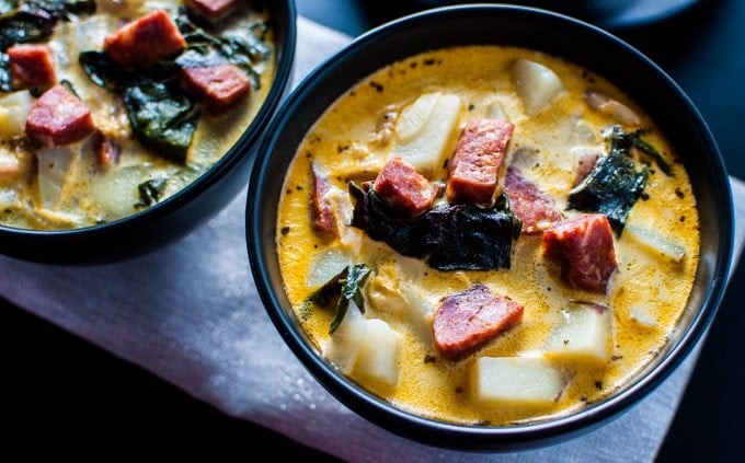 chorizo, white bean, and potato soup in a black bowl close-up