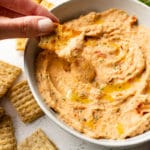 close-up of a cracker being dipped into cannellini bean dip
