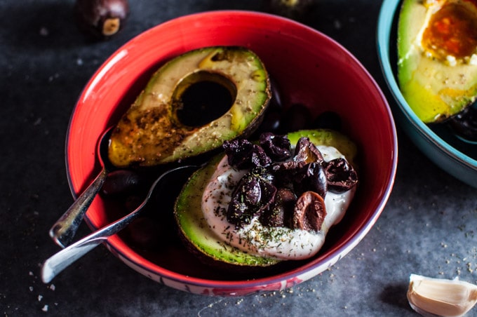 red bowl with two avocado halves