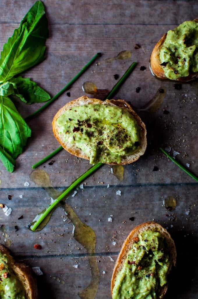 close-up of baguette slices topped with avocado pesto