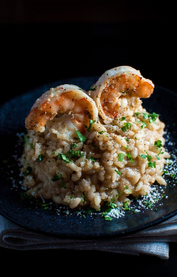 lemon risotto on a plate with two shrimps on top