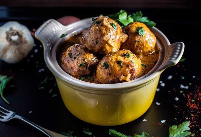 close-up of chicken meatballs with a paprika sour cream sauce in a yellow bowl