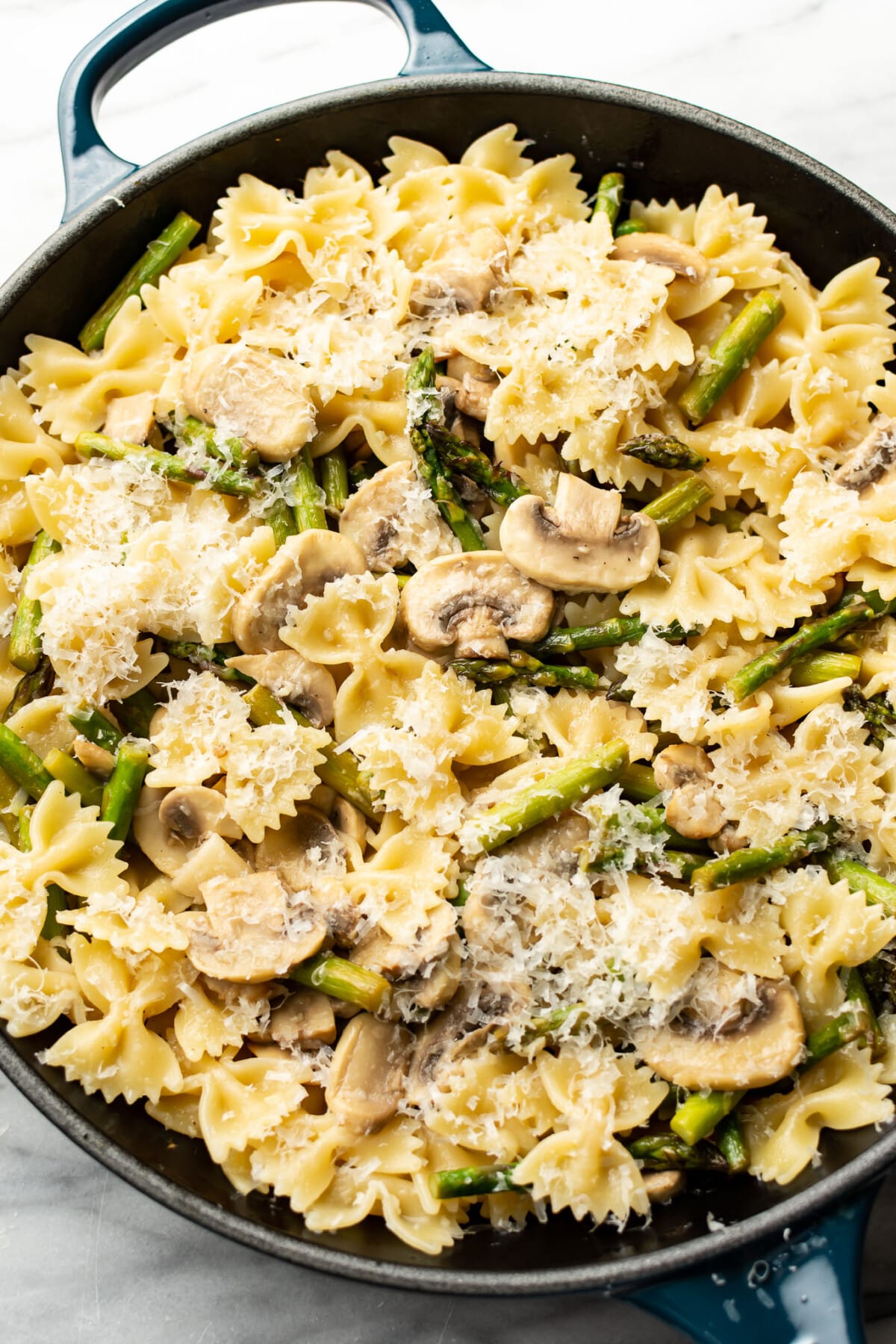 a skillet with asparagus mushroom pasta