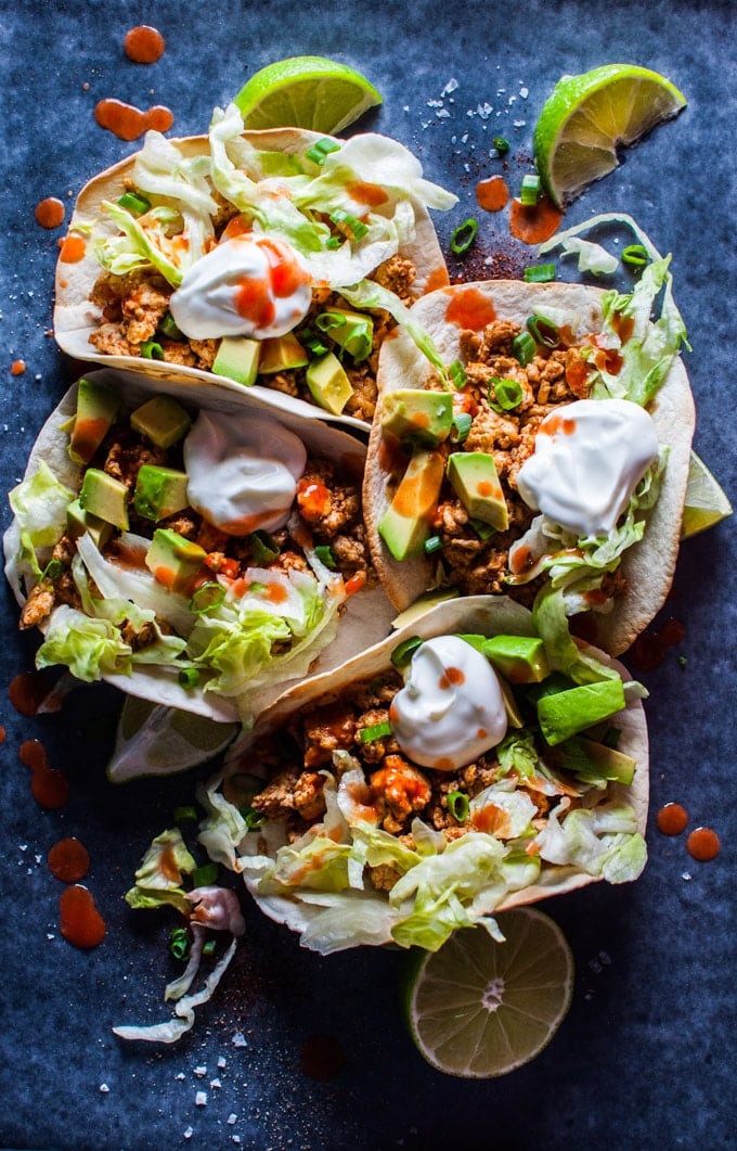 buffalo chicken tacos with hot wing sauce, sour cream, and avocado