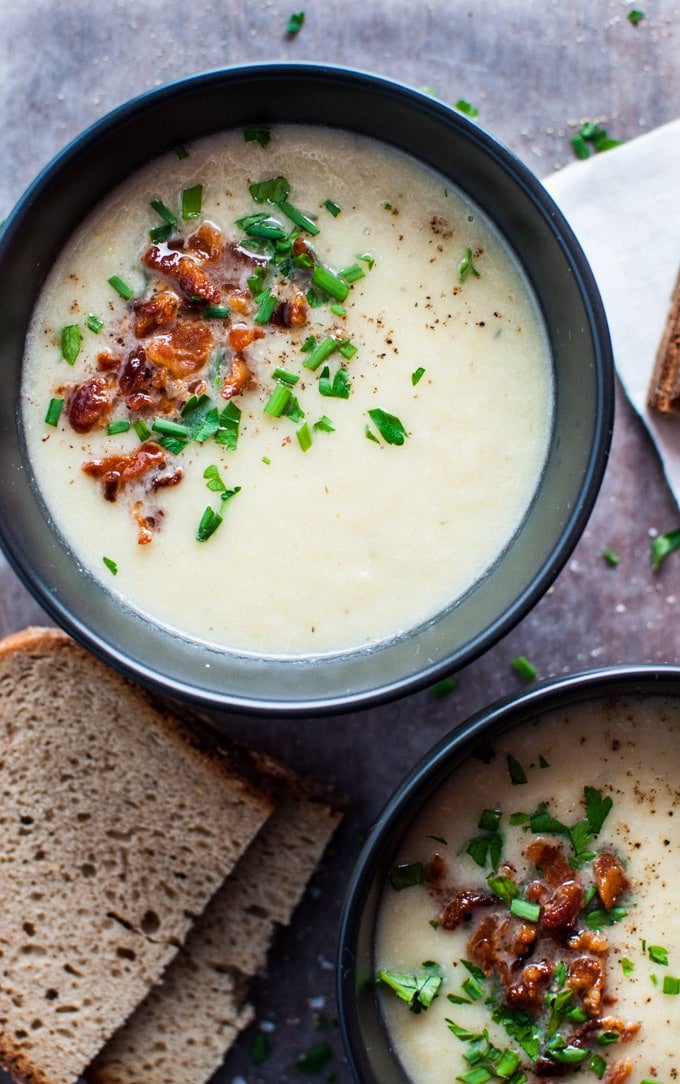 healthy cauliflower and leek soup with bacon in a black bowl