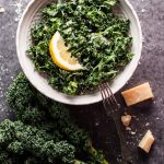 a bowl of kale salad with parmesan, lemon, and black truffle oil with a fork