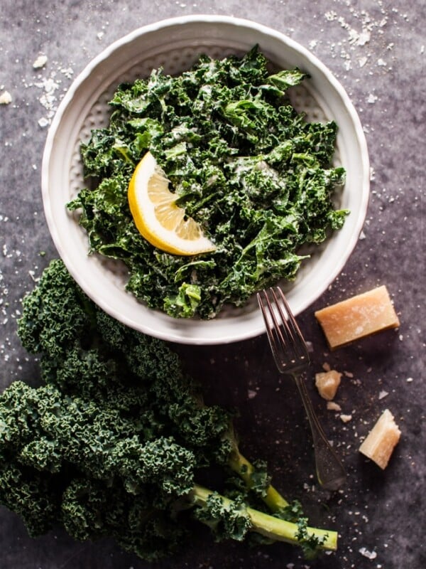 a bowl of kale salad with parmesan, lemon, and black truffle oil with a fork