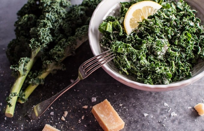 close-up of a bowl with kale salad with parmesan, lemon, and black truffle oil