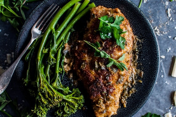 close-up of parmesan crusted chicken breasts with a fresh herb sauce