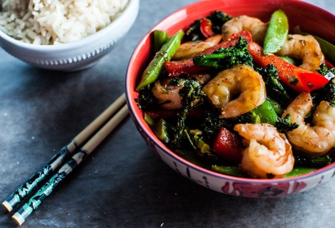 close-up of skinny shrimp stir fry with vegetables beside chopsticks