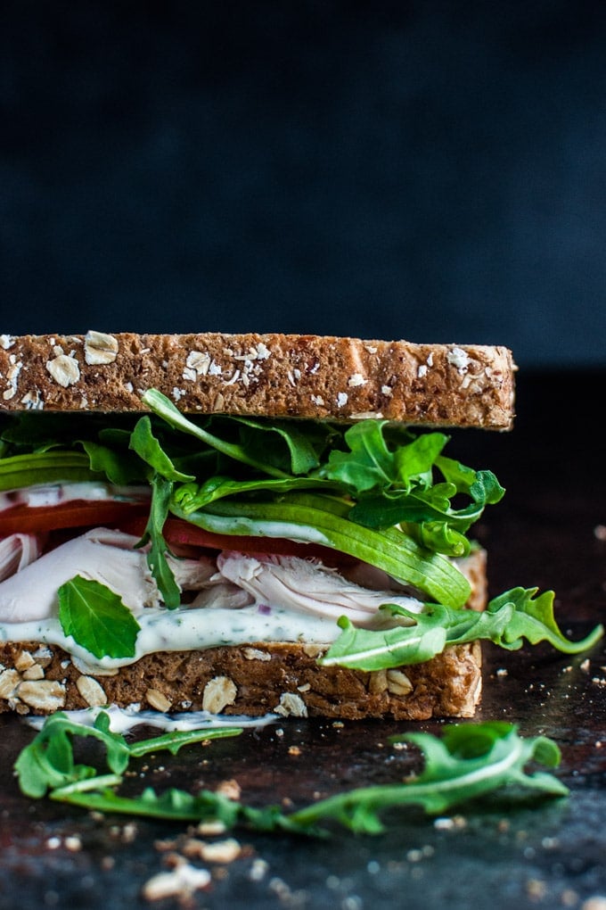 close-up of the best leftover chicken sandwich with a herb mayo, avocado, tomato, and arugula