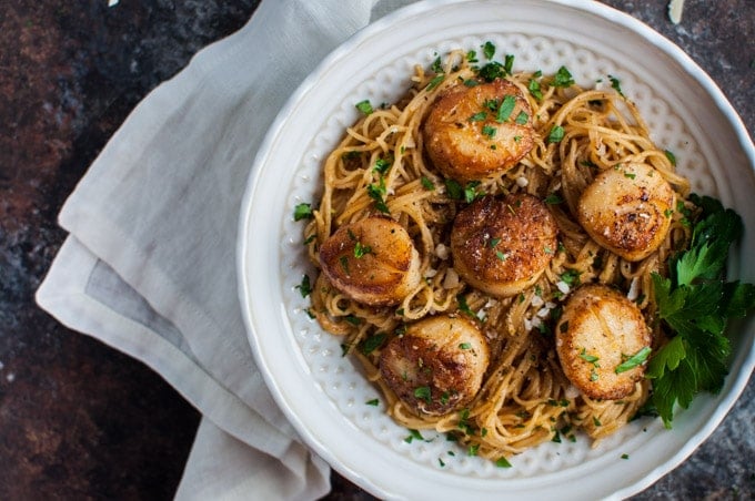 close-up of bowl with chipotle tarragon scallops with angel hair pasta