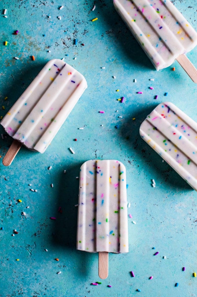 vanilla Greek yogurt funfetti popsicles on a blue counter