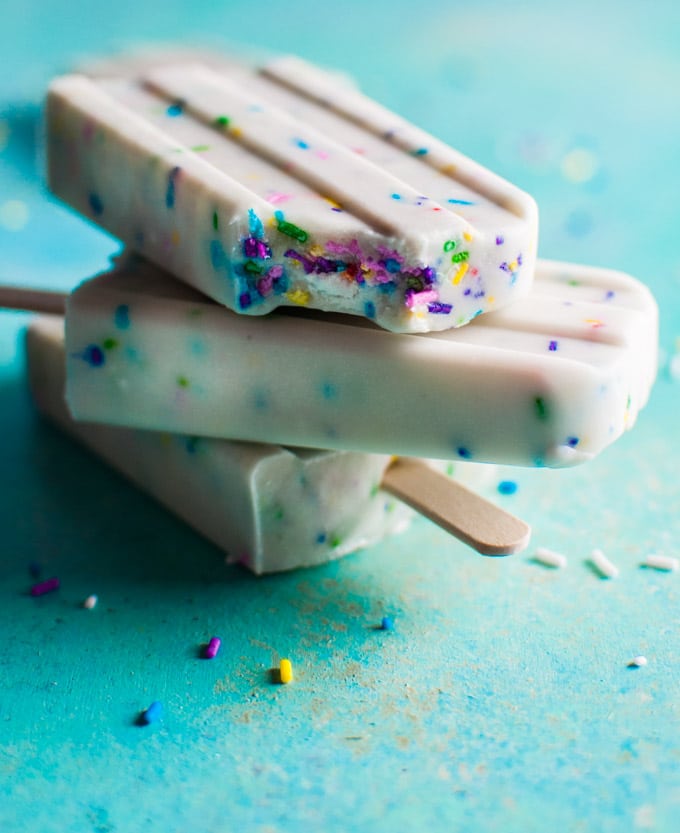 a stack of three Greek yogurt funfetti popsicles with one that has a bite taken