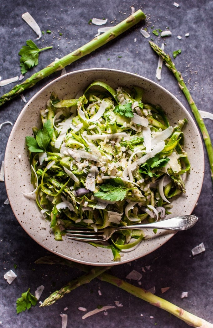 bowl of shaved asparagus salad with lemon Dijon dressing, parsley, and parmesan cheese