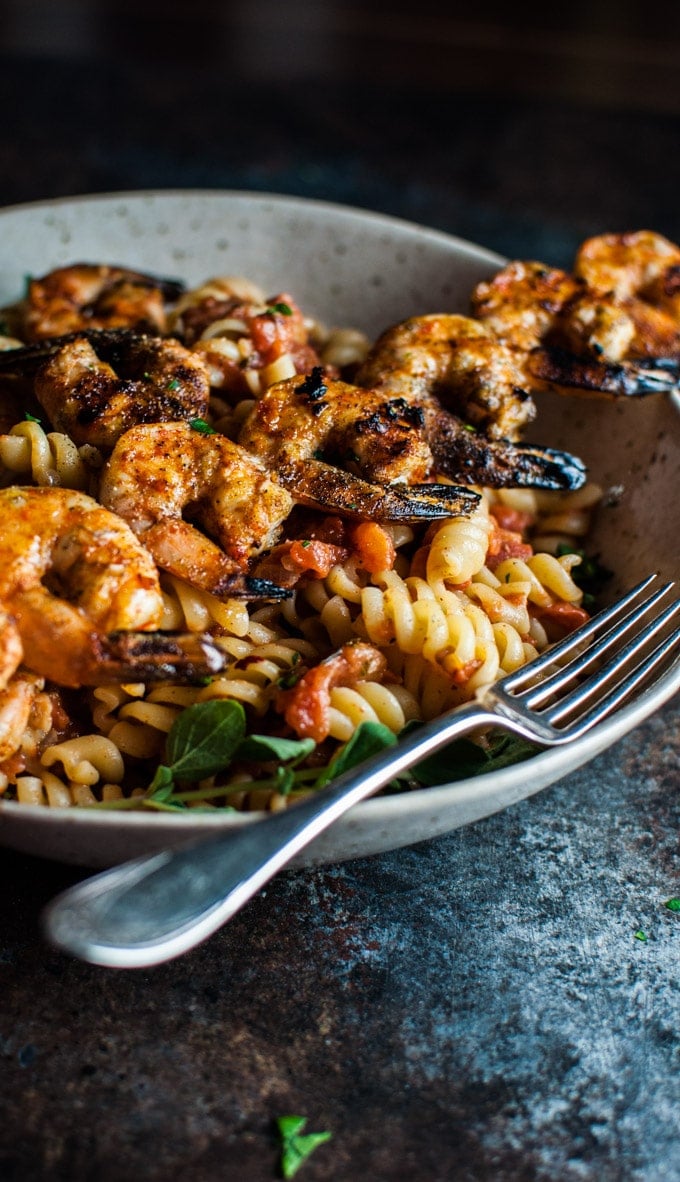 close-up of spicy grilled shrimp pasta in a bowl with a fork