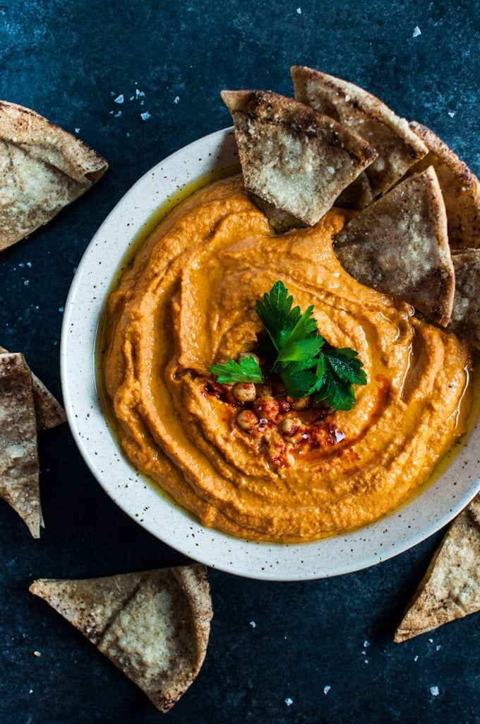 bowl of roasted red pepper sriracha hummus and pita bread