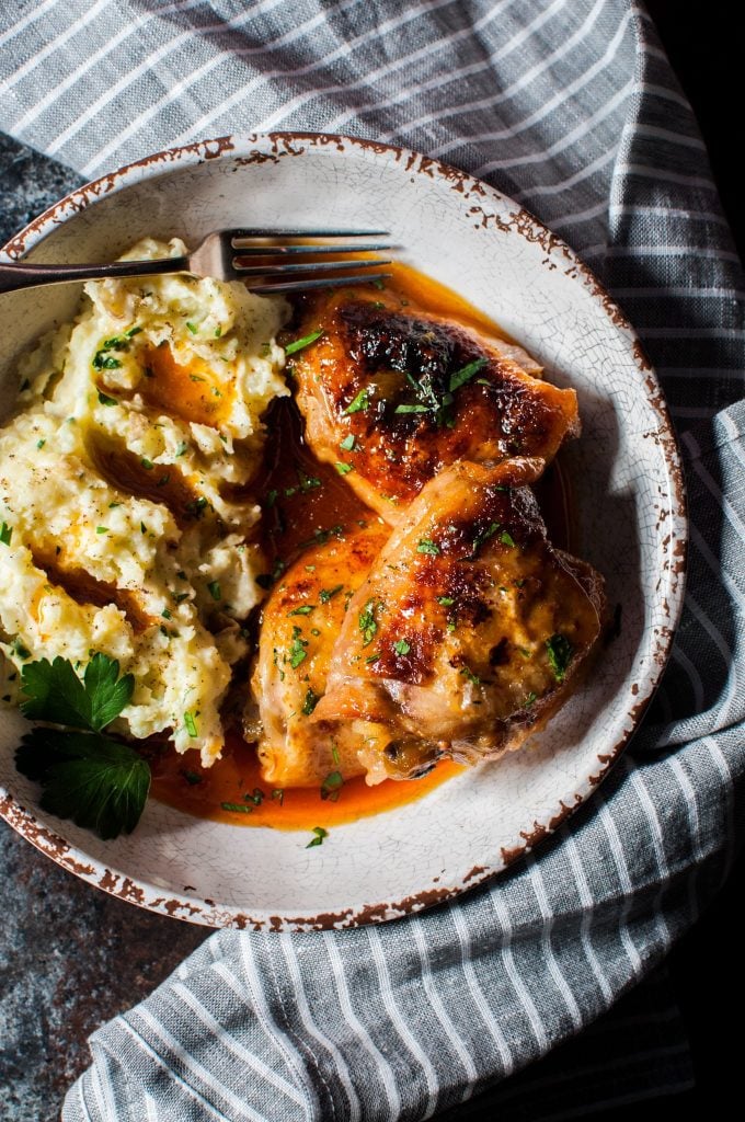 plate with crispy braised apricot chicken and mashed potatoes and a fork