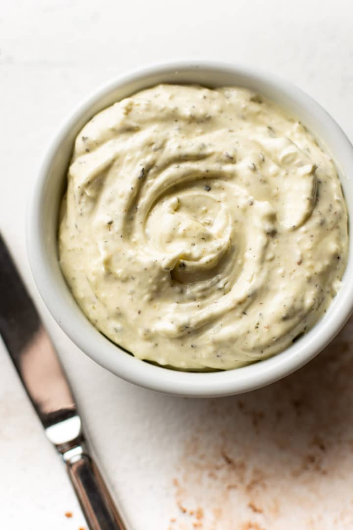 close-up of garlic herb spreadable butter in a small white bowl