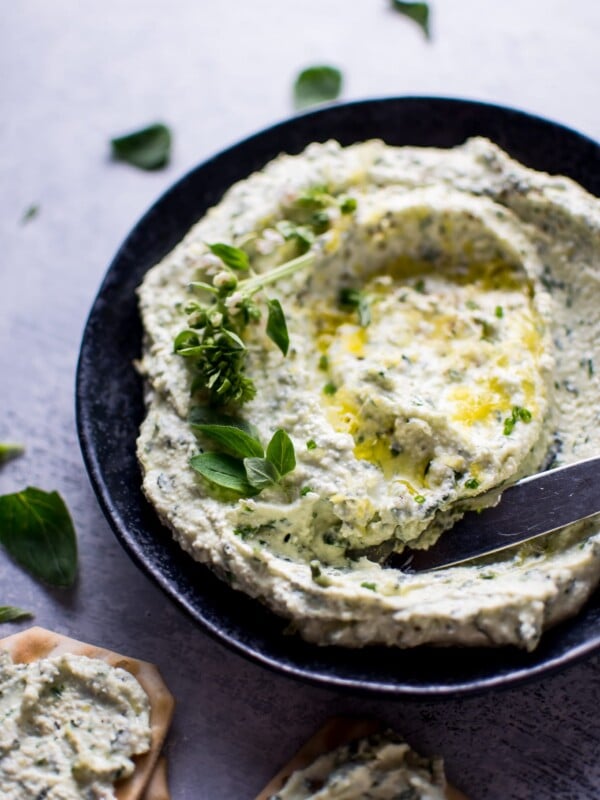 bowl with whipped feta with fresh herbs and a knife