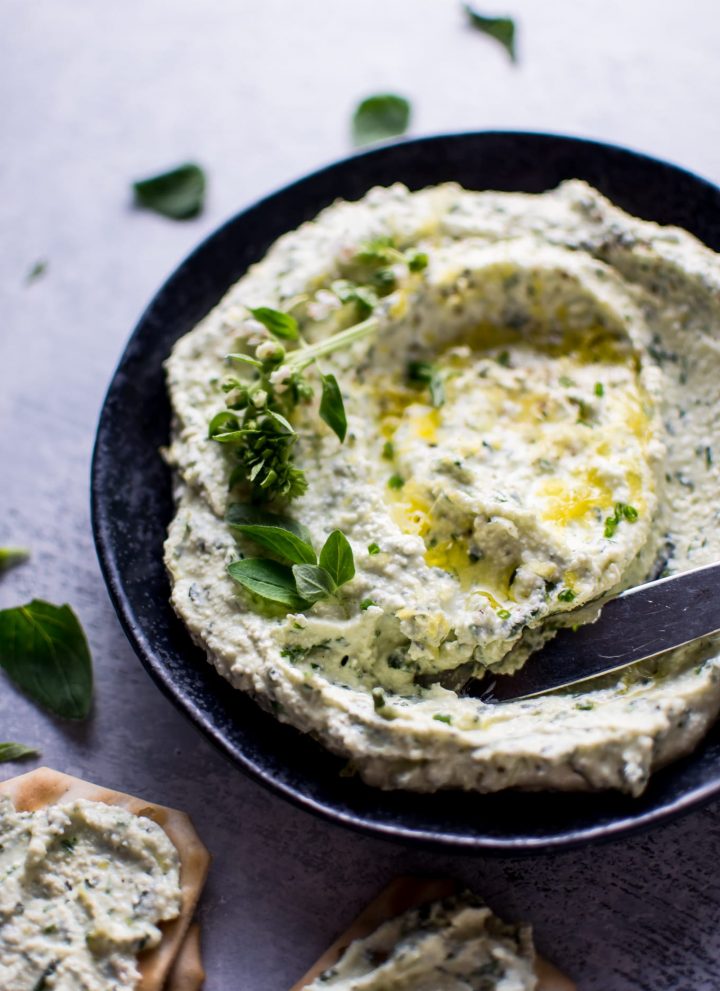 bowl with whipped feta with fresh herbs and a knife